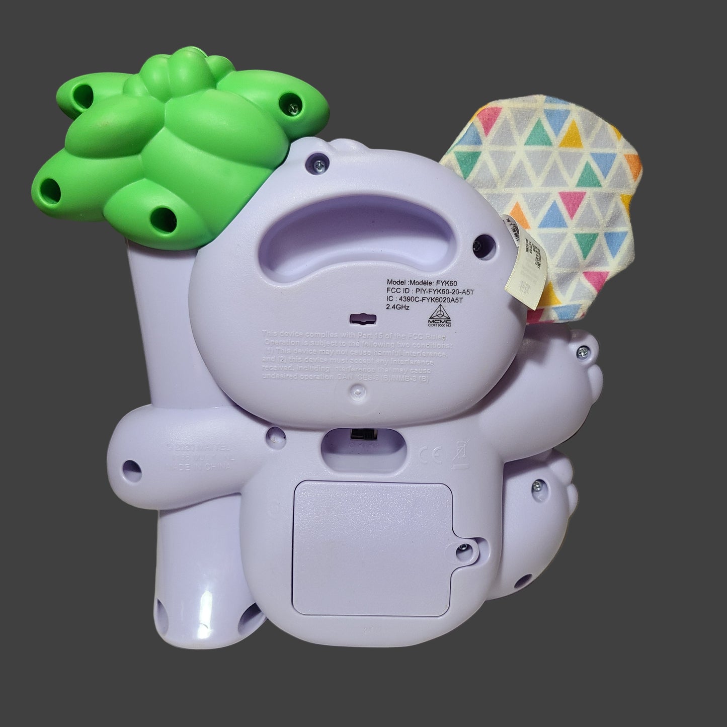 Children's toy with green frog attachment on a neutral background