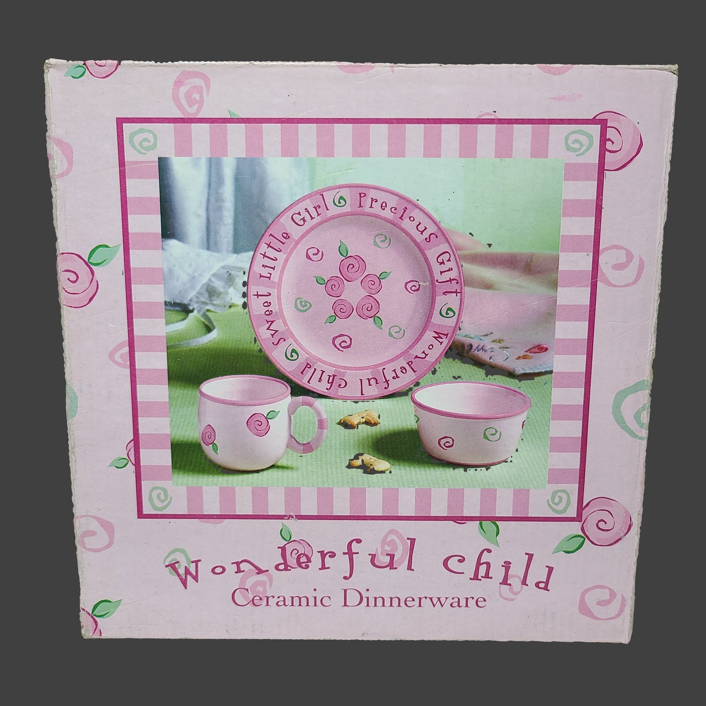 Box of children's ceramic dinnerware set with pink and green design in pink box