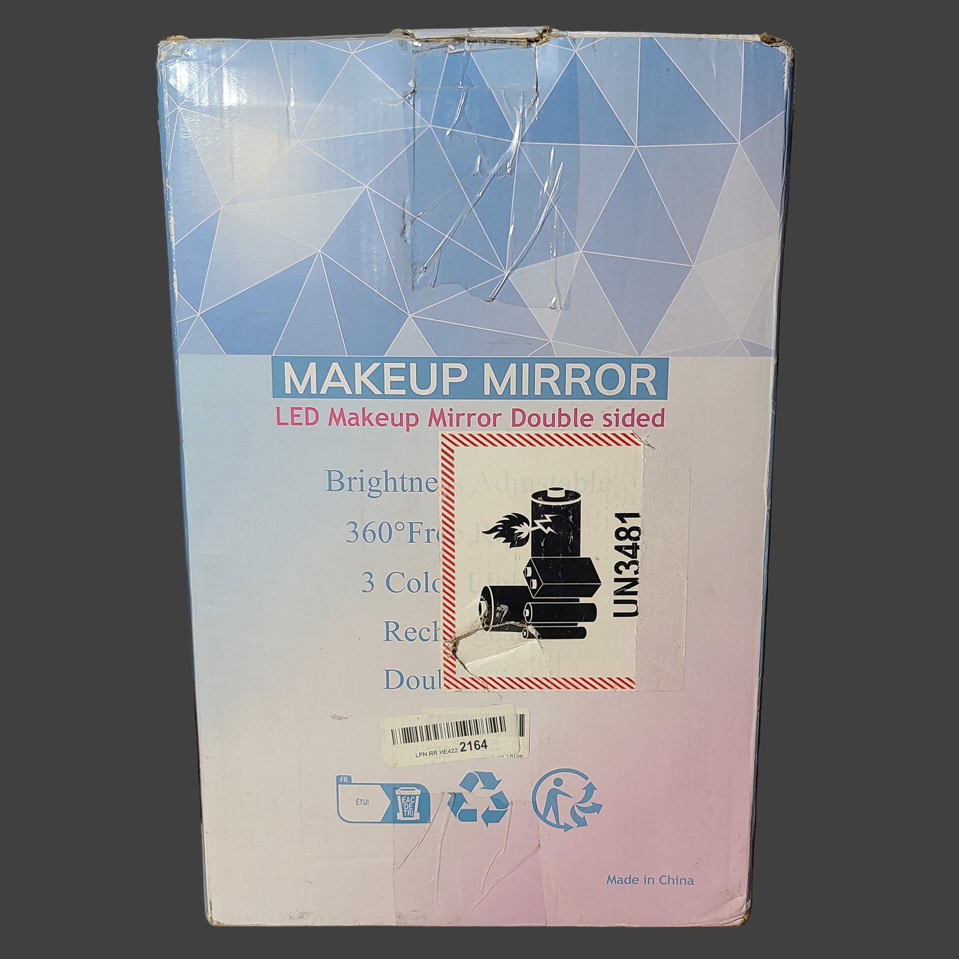 Makeup mirror packaging with geometric design on a gray surface